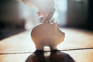 Poner un dólar en una alcancía en casa.