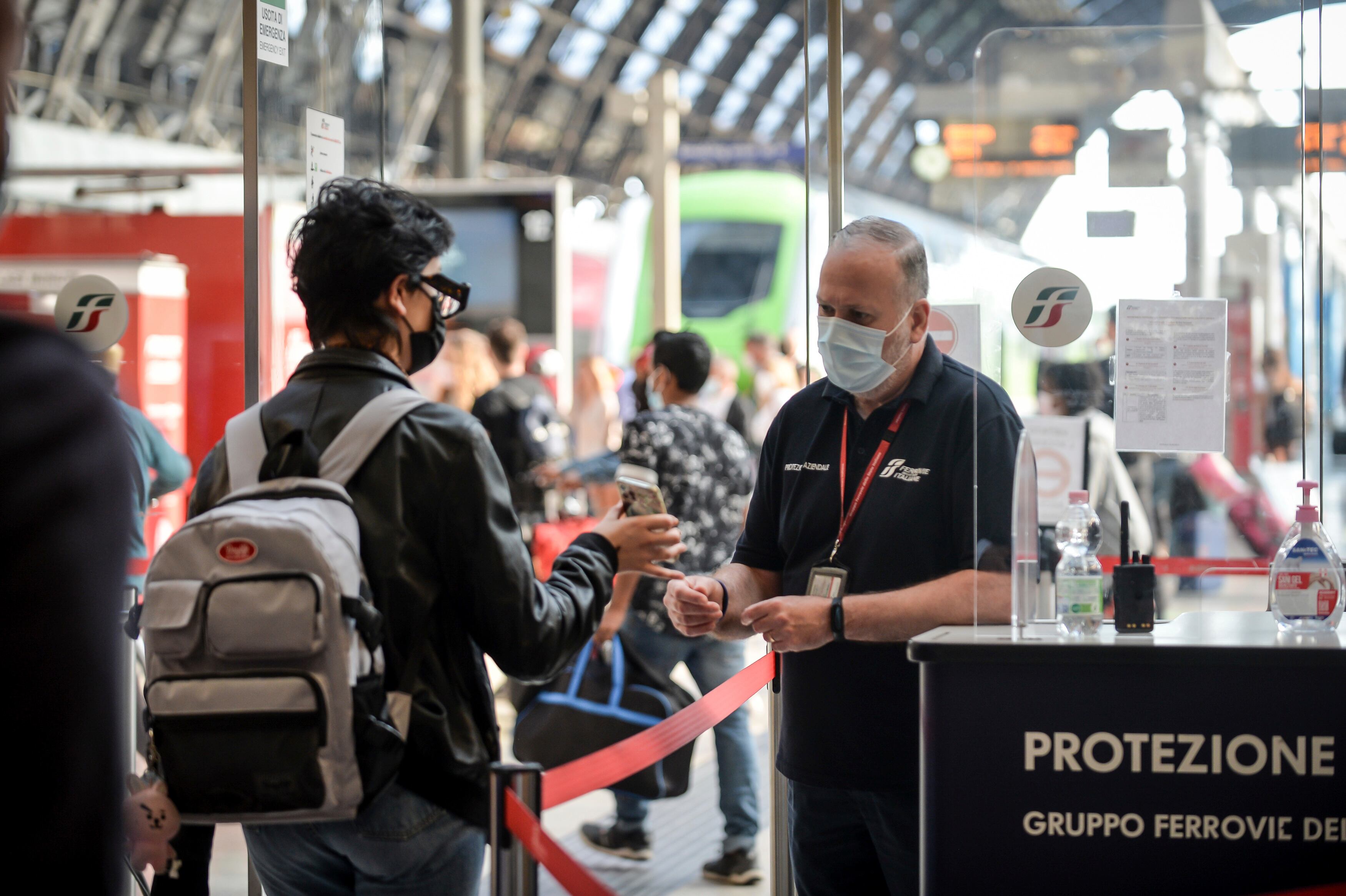 Un pasajero sostiene su teléfono en un punto de control en la estación de tren Stazione Centrale de Milán, Italia. (Claudio Furlan / LaPresse vía AP)