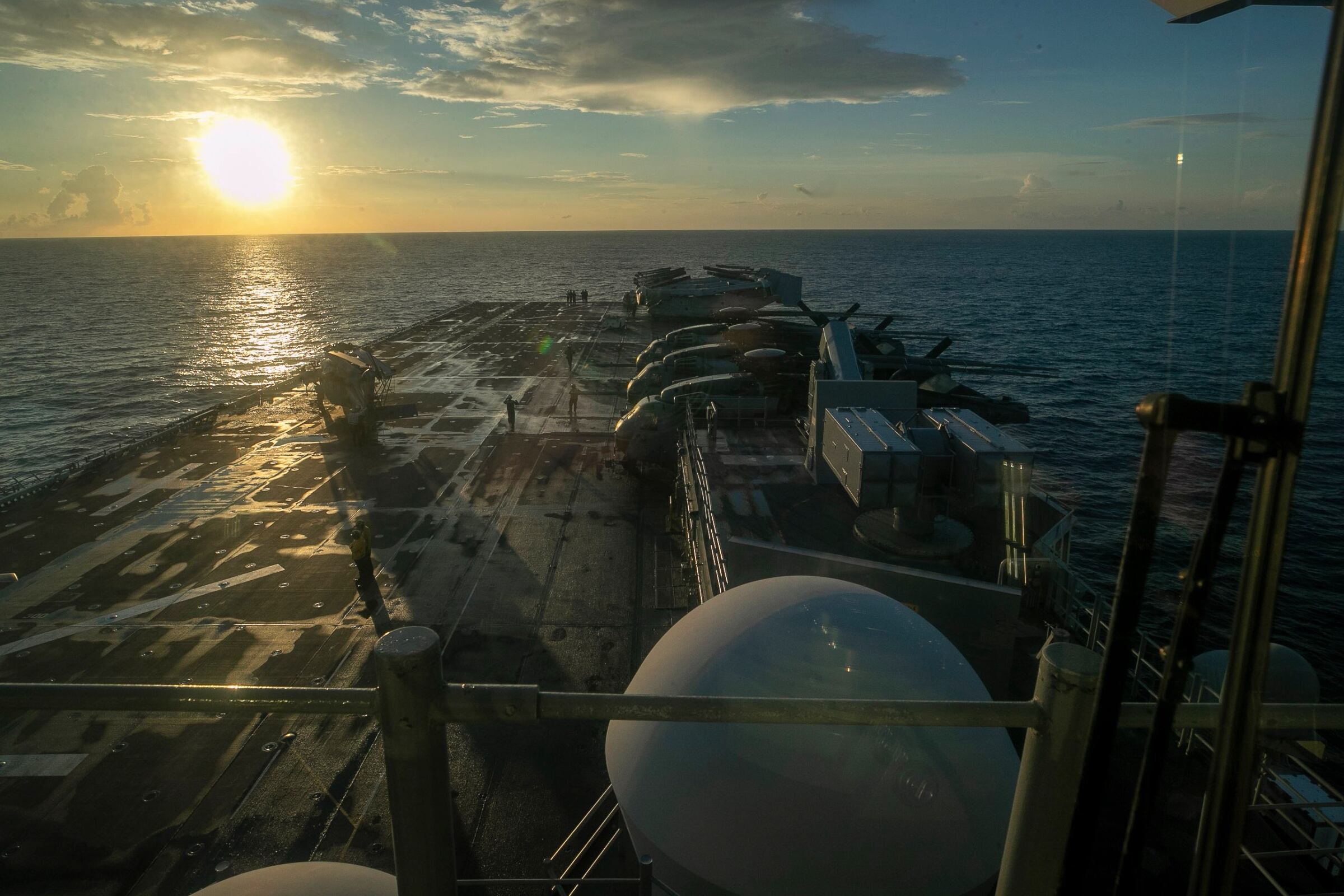 Esta imagen, tomada de un video proporcionado por el Comando Central de los Estados Unidos, muestra a marineros e infantes de marina estadounidenses a bordo del USS Tripoli llegando al área de responsabilidad del Comando Central de los Estados Unidos.