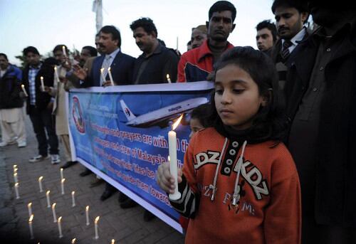 Miembros de la comunidad cristiana paquistaní participan en una vigilia para rezar por los desaparecidos del avión de Malaysia Airlines en Islamabad, Pakistán. 