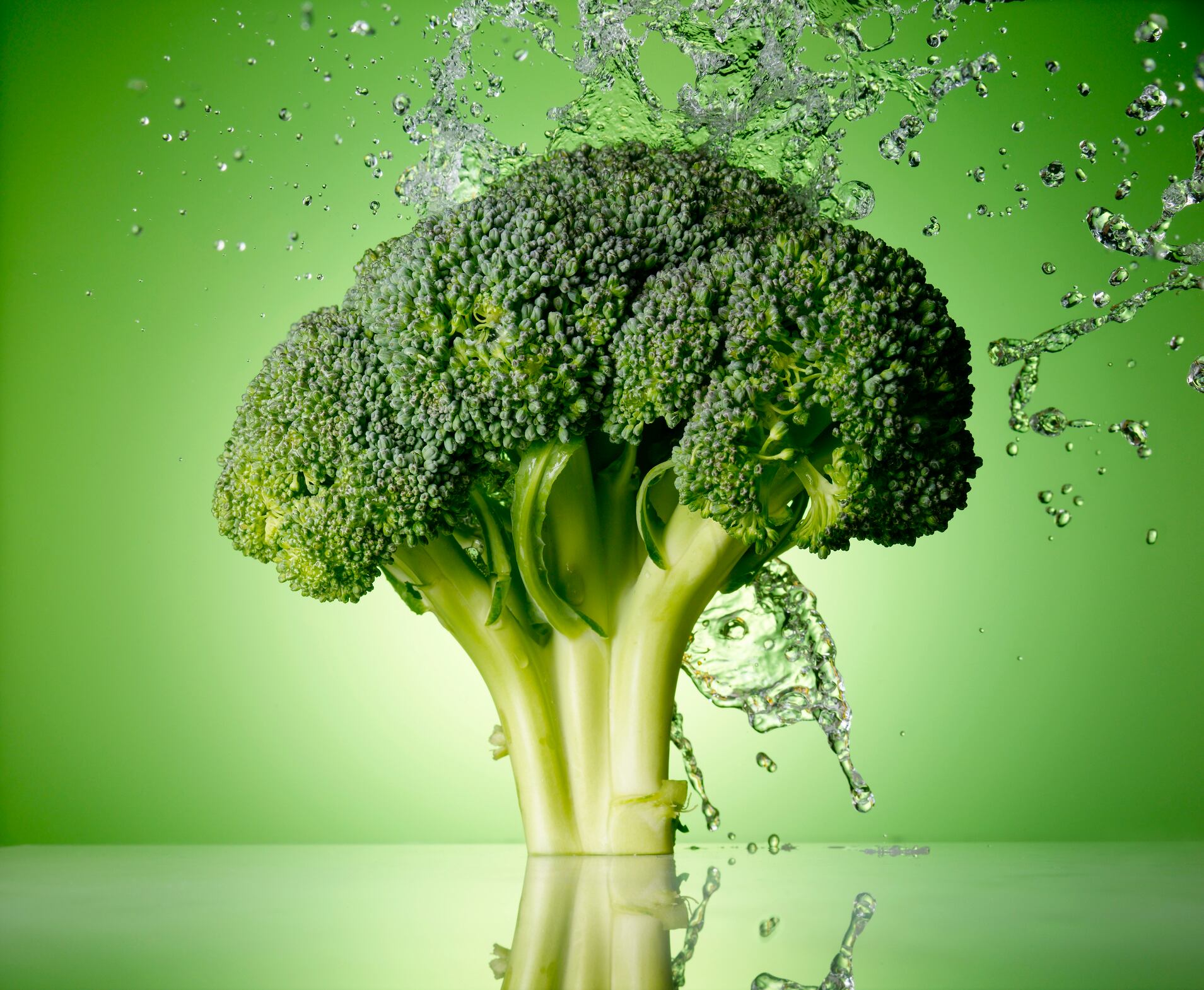Broccoli on Green background with water splash