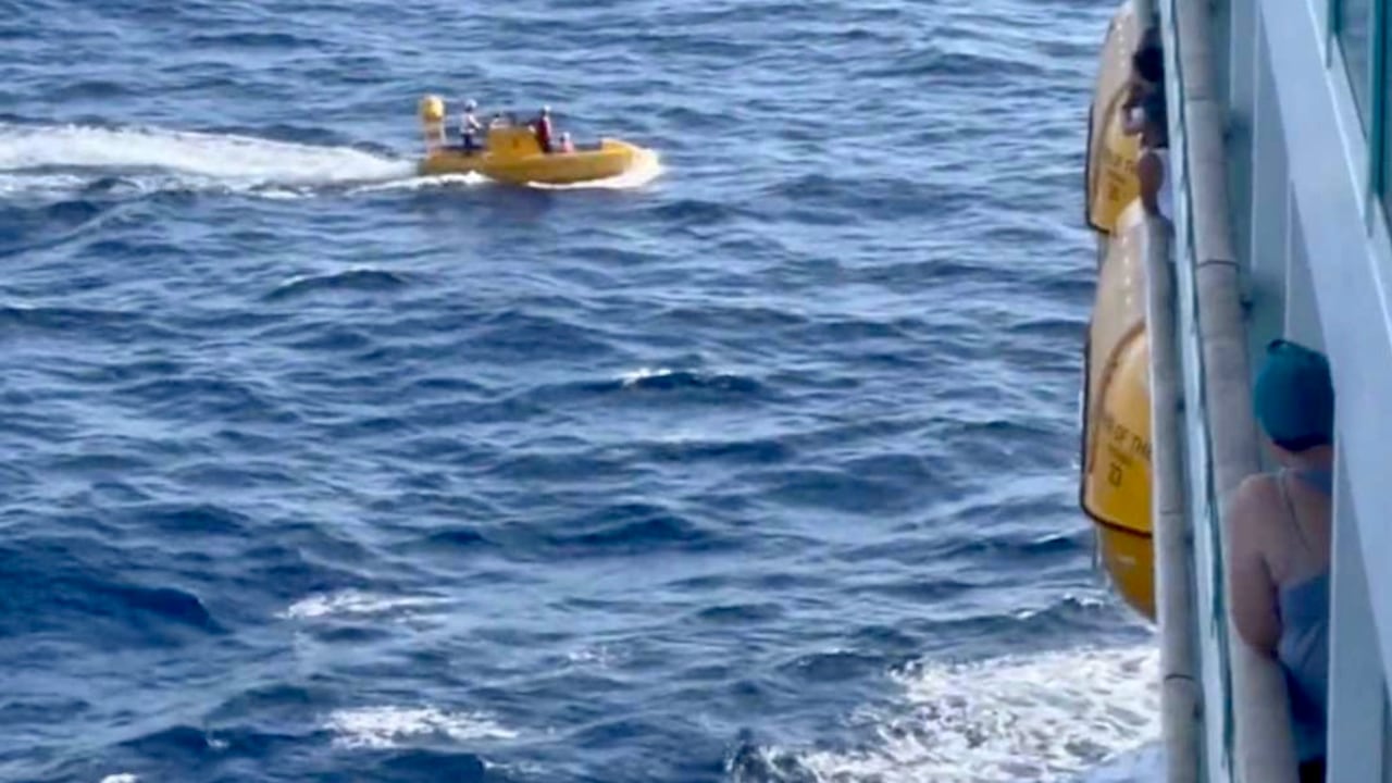 El pasajero Matthew Kuhn publicó en Twitter esta foto del momento del rescate de la mujer en un pequeño bote salvavidas. Twitter @matthew_kuhn