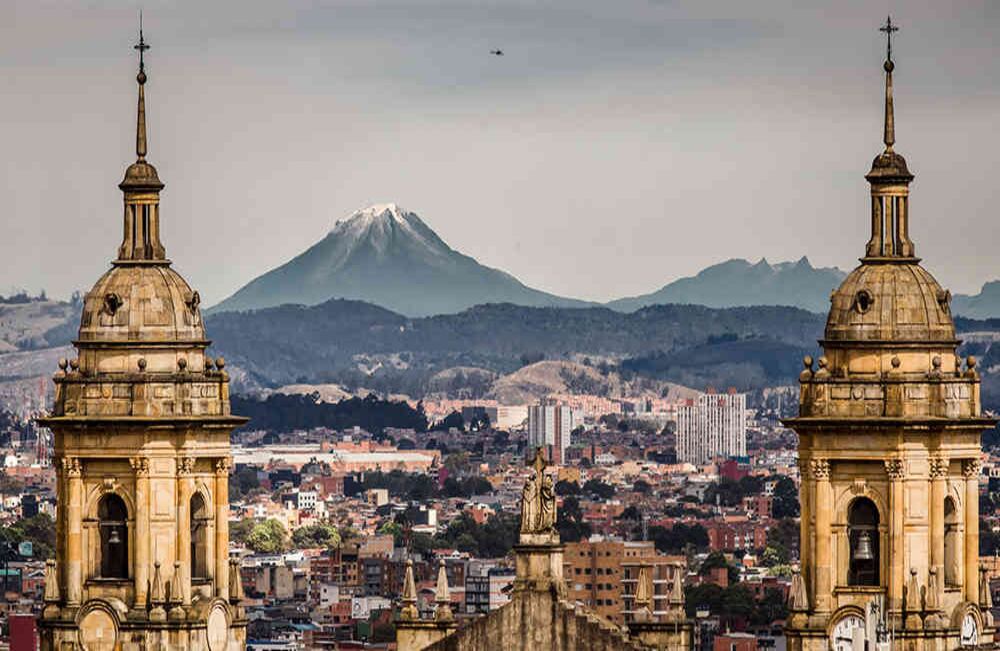 Vista de la Catedral Primada de Bogotá, y, al fondo, el Volcán Nevado del Tolima y el Volcán Paramillo del Quindío.