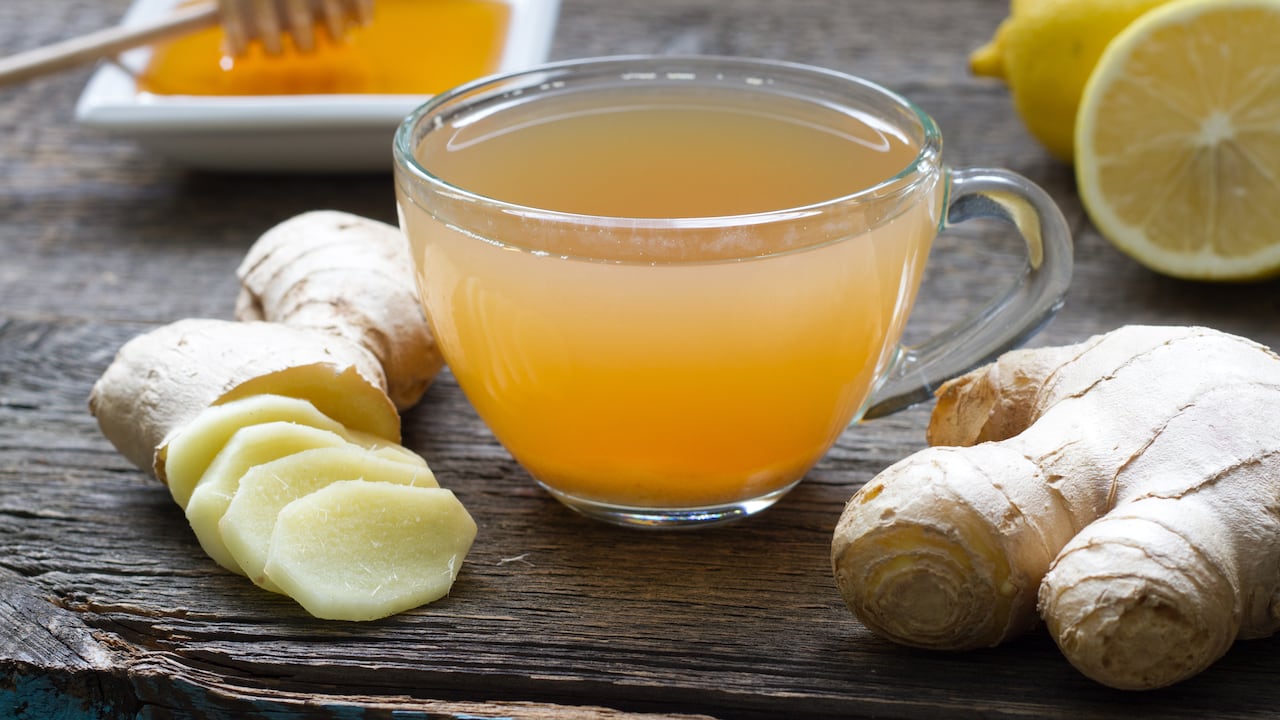 Ginger homemade tea infusion on wooden board with lemon still life