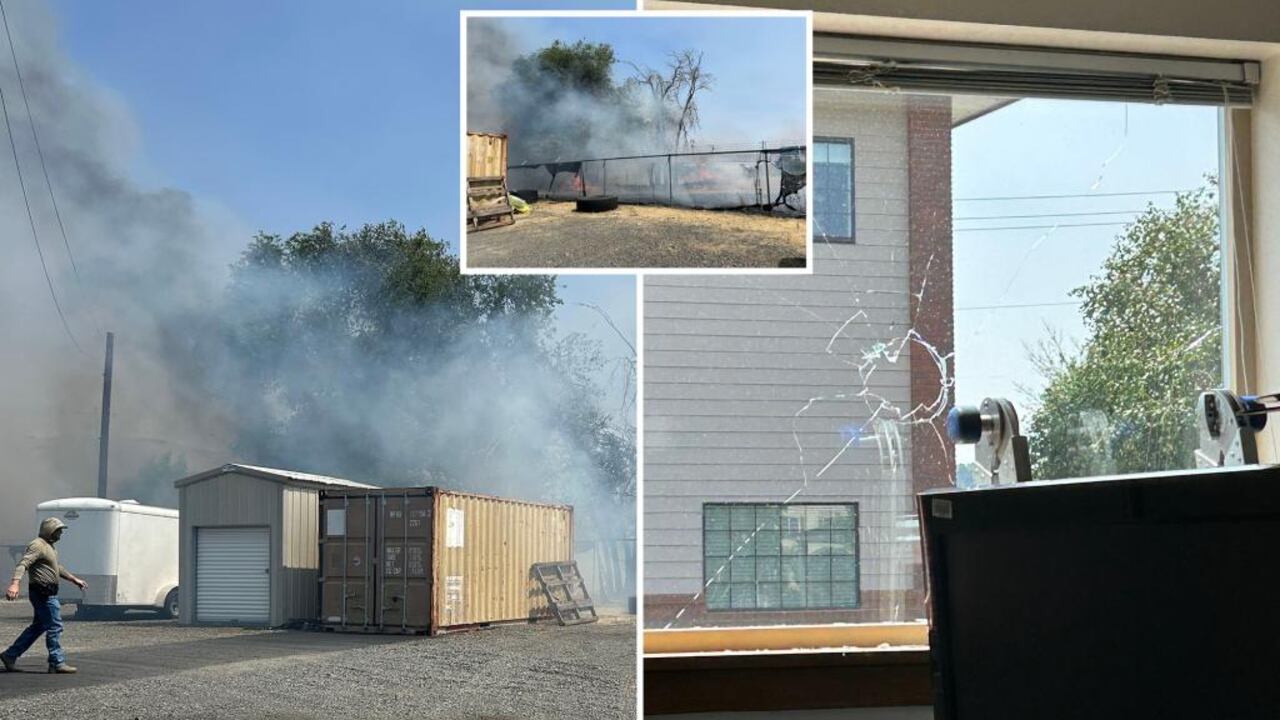 Agentes federales observan la parte trasera de una oficina de ICE con cercas quemadas y señales visibles de vandalismo, tras un ataque incendiario en Yakima, Washington.