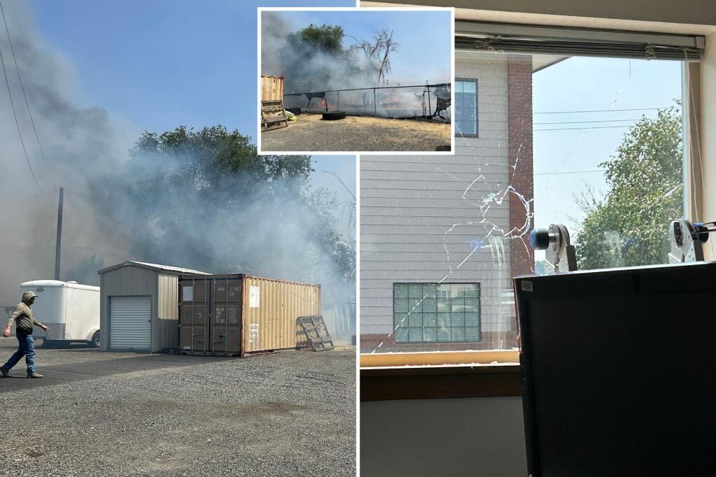 Agentes federales observan la parte trasera de una oficina de ICE con cercas quemadas y señales visibles de vandalismo, tras un ataque incendiario en Yakima, Washington.