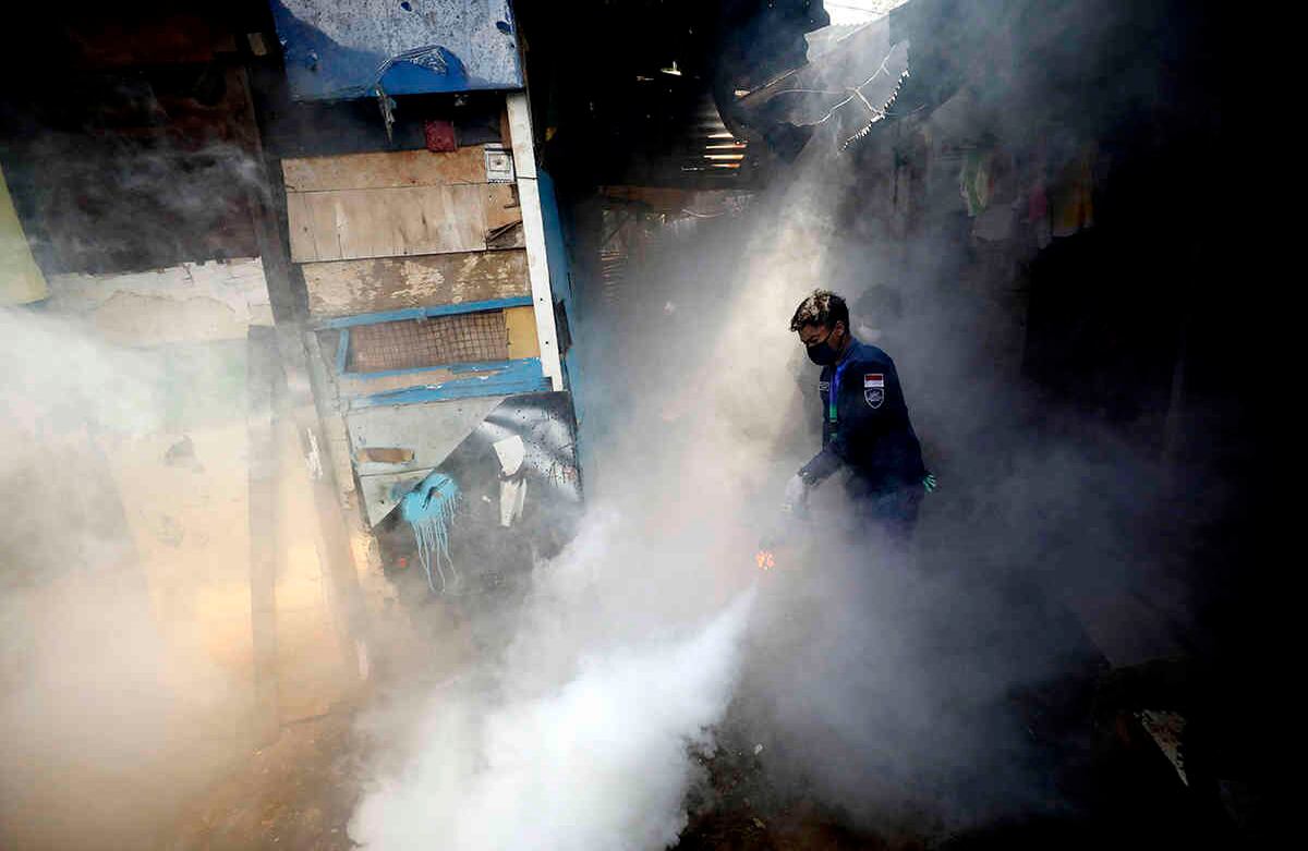 Un trabajador fumiga una zona de asentamientos irregulares con el fin de prevenir el brote de dengue en Yakarta, Indonesia, el 22 de abril. El presidente de Indonesia, Joko Widodo, ha prohibido a la gente regresar a sus ciudades de origen para celebrar el Eid al-Fitr musulmán, en medio de advertencias de expertos sanitarios de que el país podría sufrir una explosión de casos de coronavirus si el gobierno no adopta medidas más estrictas. Foto: Dita Alangkara/ AP. 
