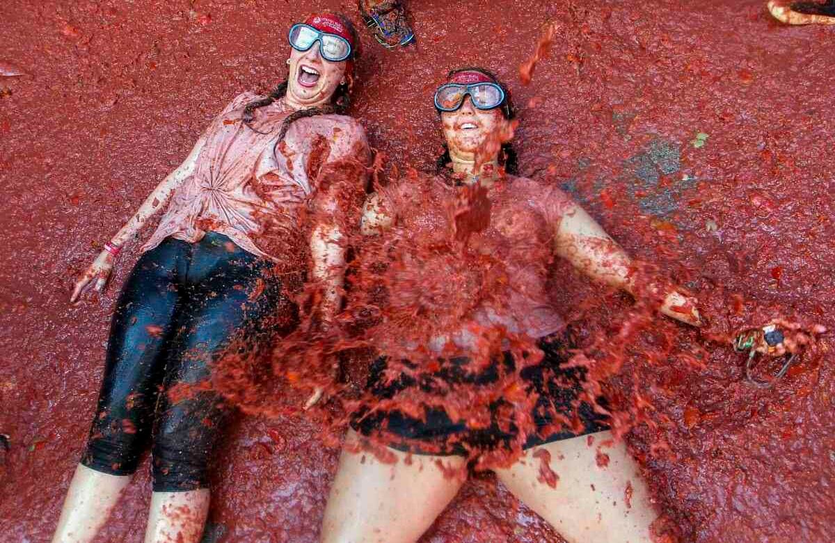 Juerguistas durante la "Tomatina" anual, fiesta de lucha con tomates en el pueblo de Bunol, cerca de Valencia, España, el miércoles 28 de agosto de 2019. En la fiesta se descargaron 145 toneladas de tomates de seis camiones, llenando las calles de Bunol para la batalla del mediodía del pasado miércoles. (Foto AP / Alberto Saiz)