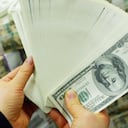 SEÚL, COREA DEL SUR - 22 DE FEBRERO: Un banquero surcoreano lleva billetes de banco en dólares estadounidenses en el banco Korea Exchange el 22 de febrero de 2005 en Seúl, Corea del Sur. El won surcoreano saltó a su nivel intradiario más alto en más de siete años en el comercio interno el martes, impulsado por fuertes compras de acciones extranjeras y dolar dolár acuerdos con exportadores. (Foto de Chung Sung-Jun/Getty Images)