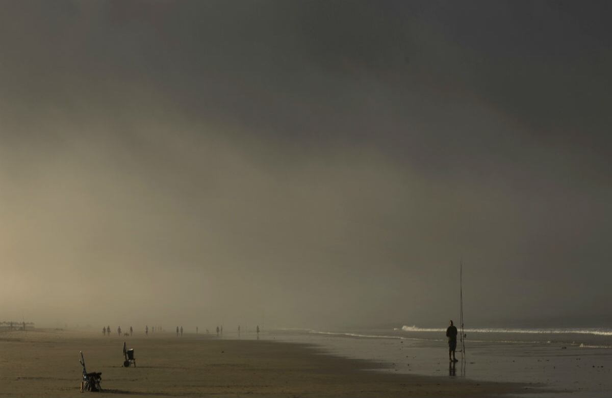 Un pescador mira su caña mientras pesca en una playa cerca a Cadiz, España. (AP)