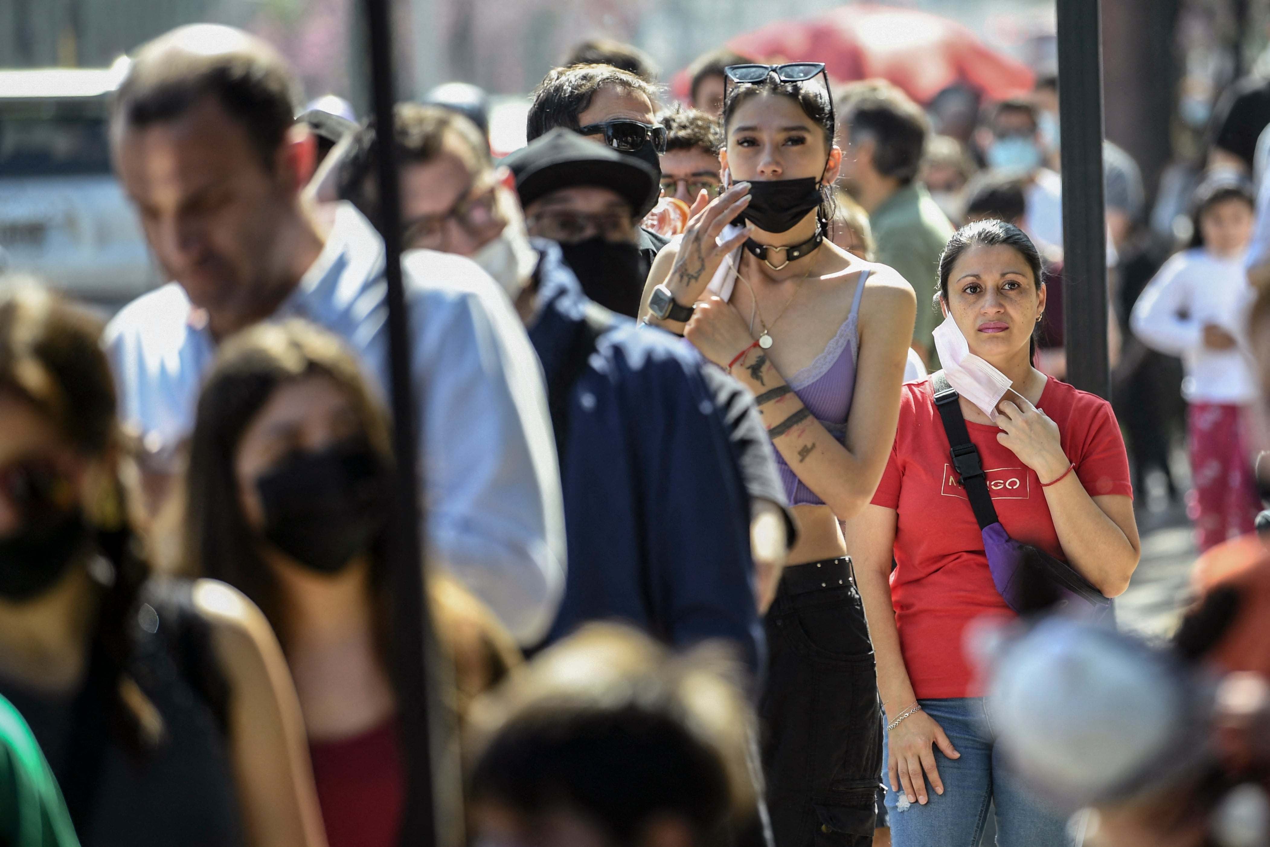 La gente hace fila para ingresar a un colegio electoral durante un referéndum para aprobar o rechazar una nueva Constitución en Santiago, el 4 de septiembre de 2022. - Más de 15 millones de votantes comenzaron este domingo a votar en Chile para aprobar o rechazar una nueva Constitución que reemplazará al heredado de la dictadura de Augusto Pinochet (1973-1990). (Foto por MARTÍN BERNETTI / AFP)