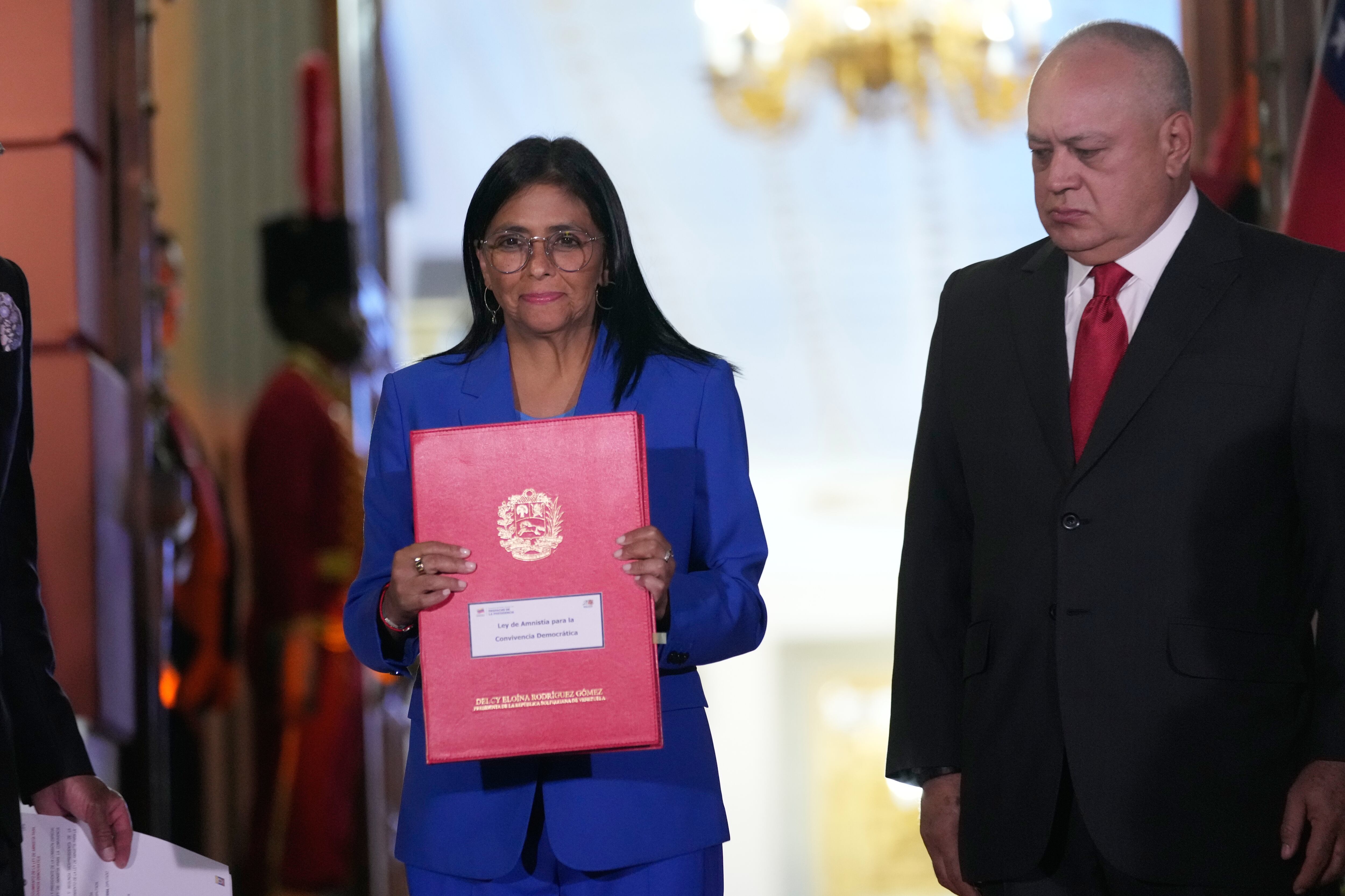 La presidenta interina de Venezuela, Delcy Rodríguez, sostiene un proyecto de ley de amnistía aprobado por la Asamblea Nacional junto con el ministro del Interior, Diosdado Cabello.
