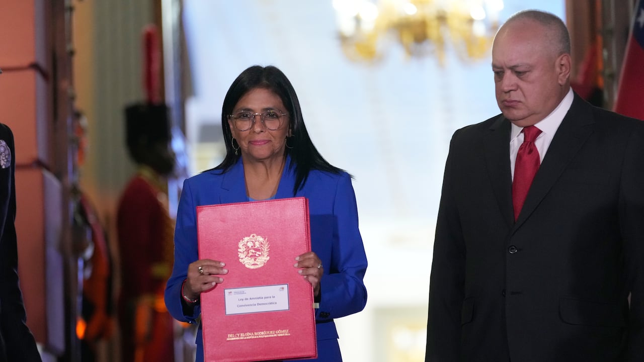 La presidenta interina de Venezuela, Delcy Rodríguez, sostiene un proyecto de ley de amnistía aprobado por la Asamblea Nacional junto con el ministro del Interior, Diosdado Cabello.