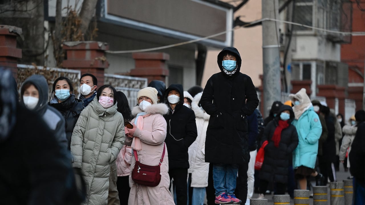 La gente espera en una larga cola para hacerse la prueba del coronavirus Covid-19 en un sitio de prueba de ácido nucleico abierto, ya que muchas estaciones de prueba están cerradas en Beijing. (Photo by Jade GAO / AFP)
