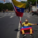 Una seguidora de la líder opositora María Corina Machado ondea una bandera venezolana durante una protesta que exige su regreso al país.