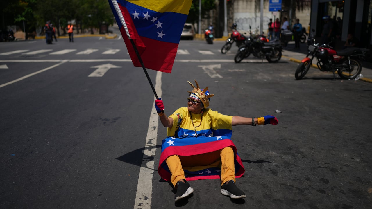 Una seguidora de la líder opositora María Corina Machado ondea una bandera venezolana durante una protesta que exige su regreso al país.