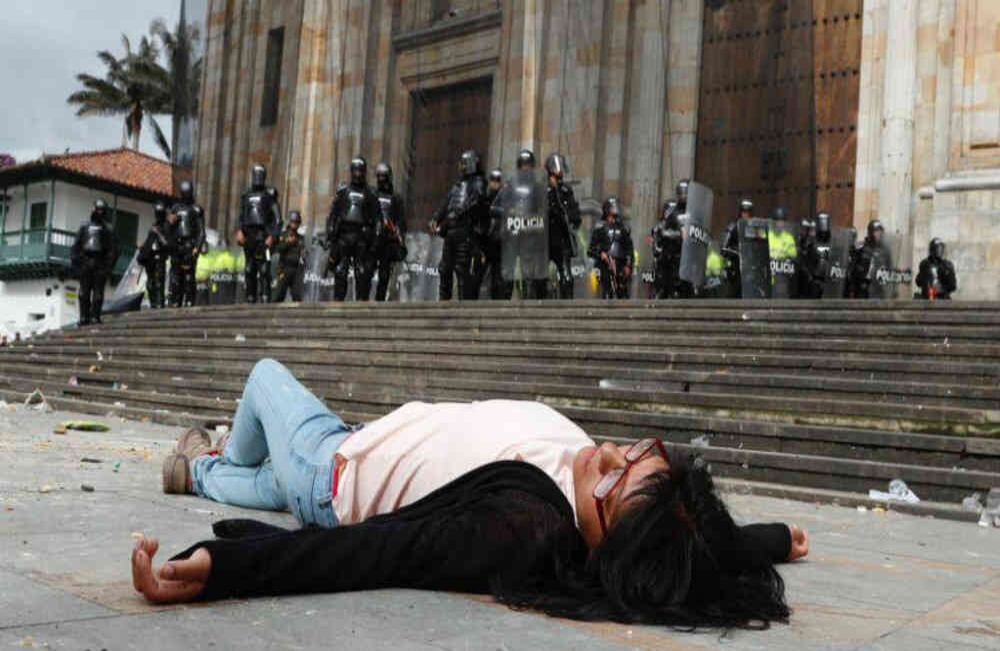 Esta estudiante decidió tirarse al piso a modo de protesta mientras que el ESMAD y los estudiantes se enfrentaban. FOTO: León Darío Peláez / Semana
