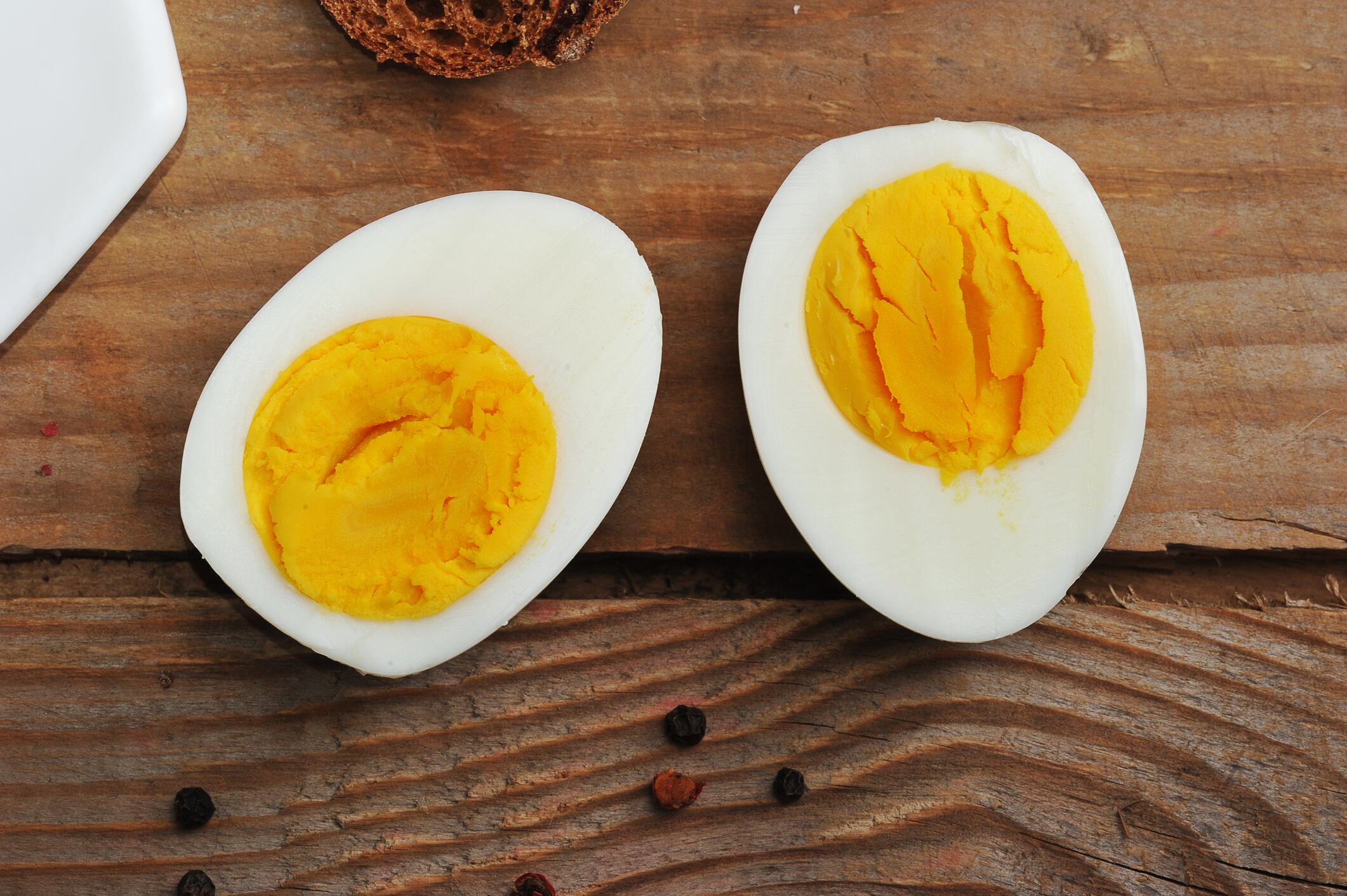 two halves of boiled eggs on wooden rustic background. the view from the top