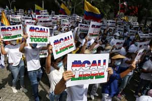 La gente sostiene carteles de "Cali Libre" en español durante una marcha silenciosa para apoyar el desbloqueo de las principales vías de entrada y salida de la ciudad que han sido bloqueadas por protestas antigubernamentales en Cali, Colombia, el martes 25 de mayo de 2021. Los colombianos han tomado a las calles durante semanas en todo el país después de que el gobierno propuso aumentos de impuestos sobre los servicios públicos, el combustible, los salarios y las pensiones. (Foto AP / Andrés González)