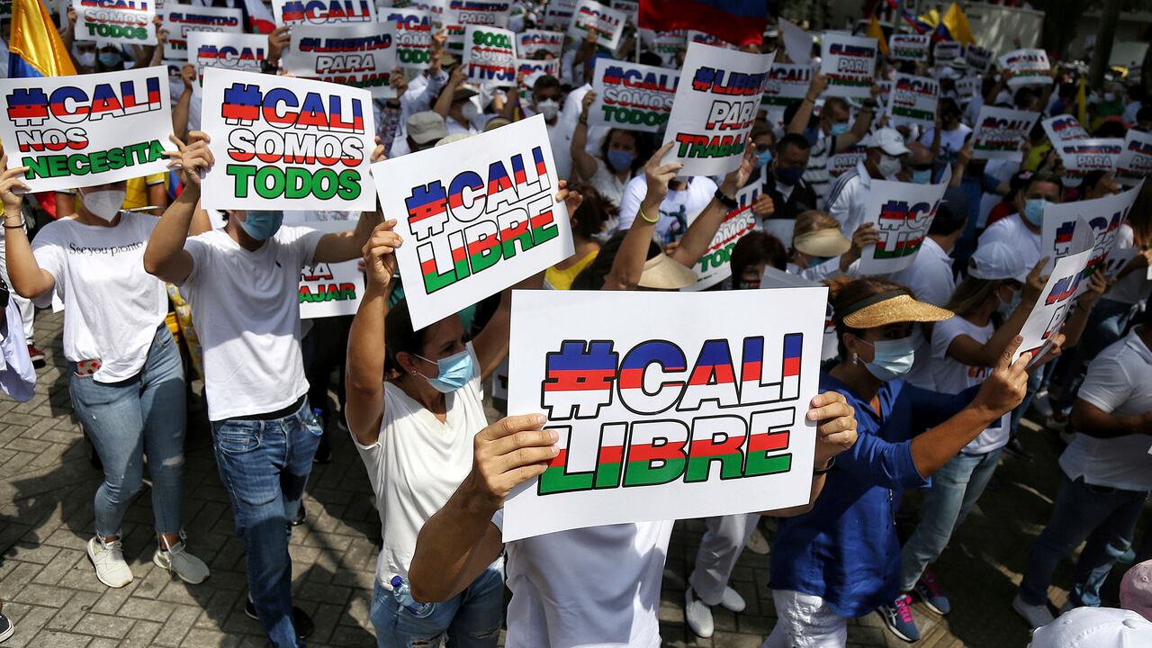 La gente sostiene carteles de "Cali Libre" en español durante una marcha silenciosa para apoyar el desbloqueo de las principales vías de entrada y salida de la ciudad que han sido bloqueadas por protestas antigubernamentales en Cali, Colombia, el martes 25 de mayo de 2021. Los colombianos han tomado a las calles durante semanas en todo el país después de que el gobierno propuso aumentos de impuestos sobre los servicios públicos, el combustible, los salarios y las pensiones. (Foto AP / Andrés González)