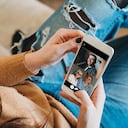 Young woman connecting with her family during quarantine. She's using a smartphone to call her family in Coronavirus COVID-19 time.