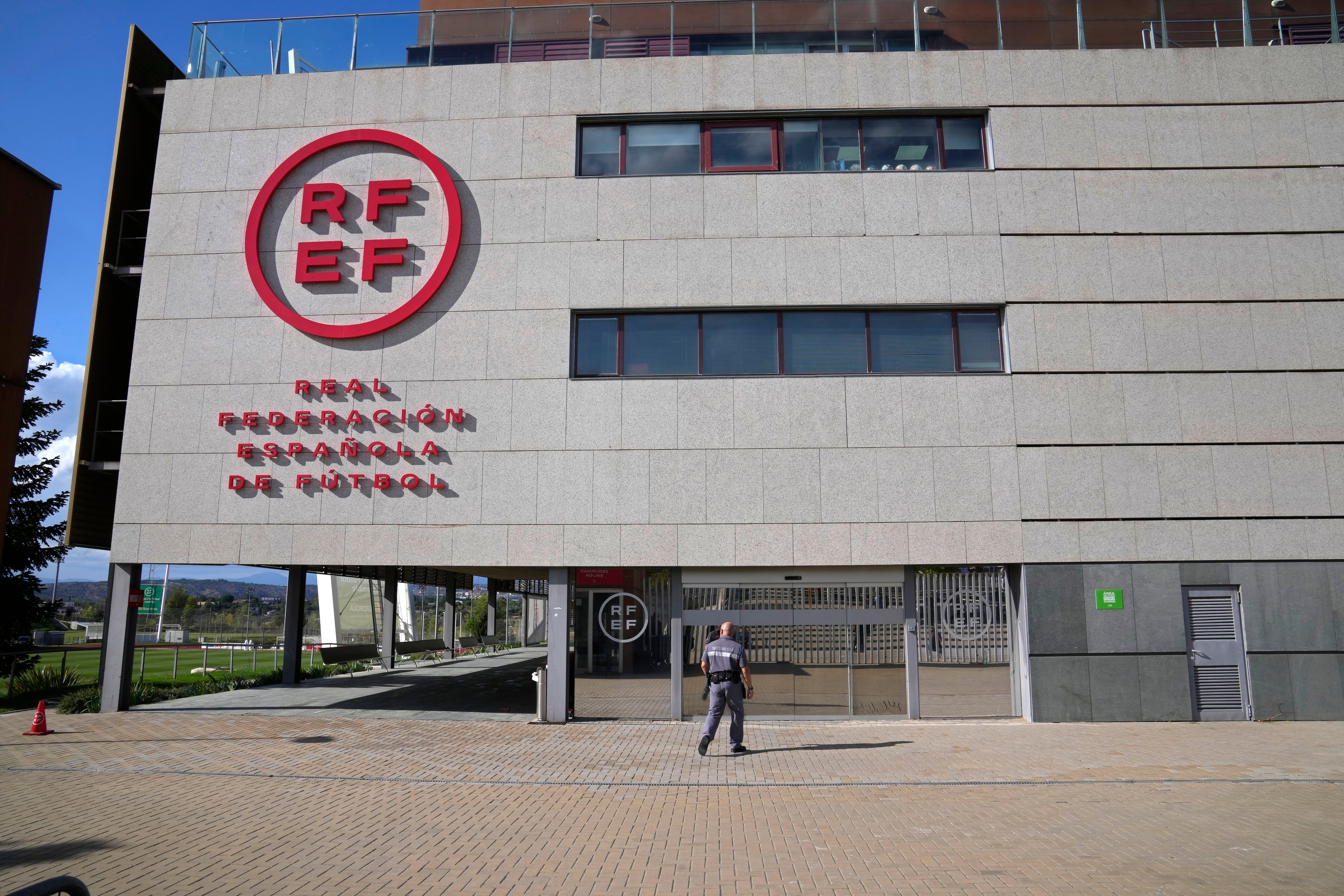 Un agente de seguridad camina hacia la sede de la Federación Española de fútbol en las afueras de Madrid, el viernes 15 de septiembre de 2023. (AP Foto/Paul White)