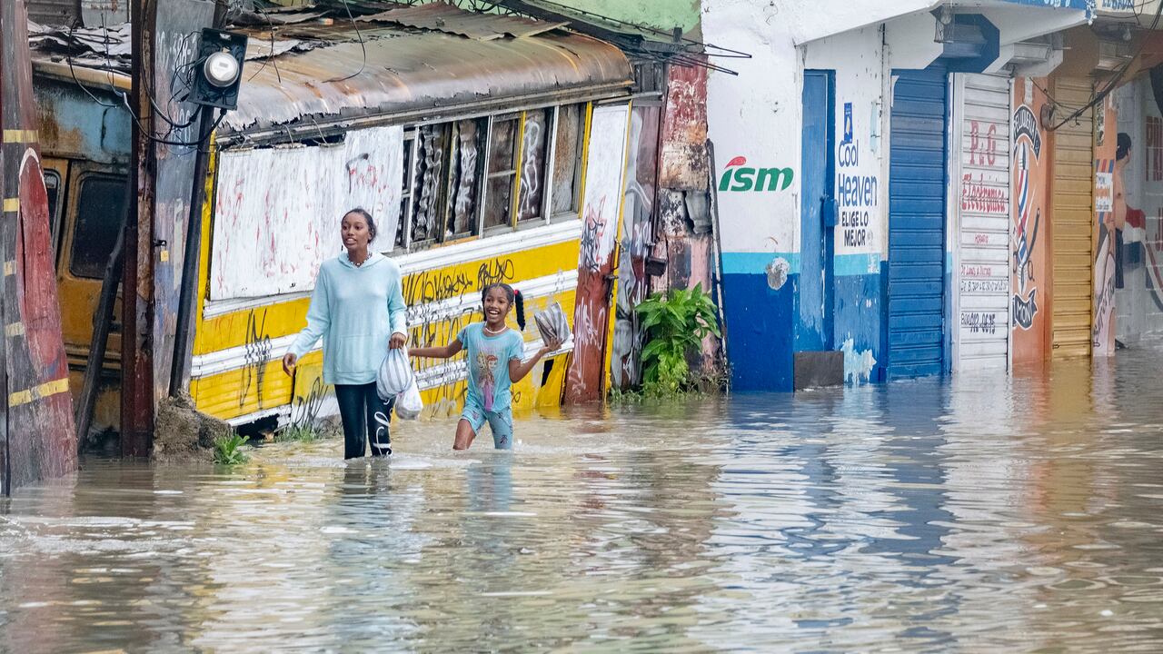Personas caminan por una calle inundada por las lluvias de la tormenta tropical Franklin en Santo Domingo, República Dominicana, el martes 22 de agosto de 2023. (Foto AP/Ricardo Hernández)