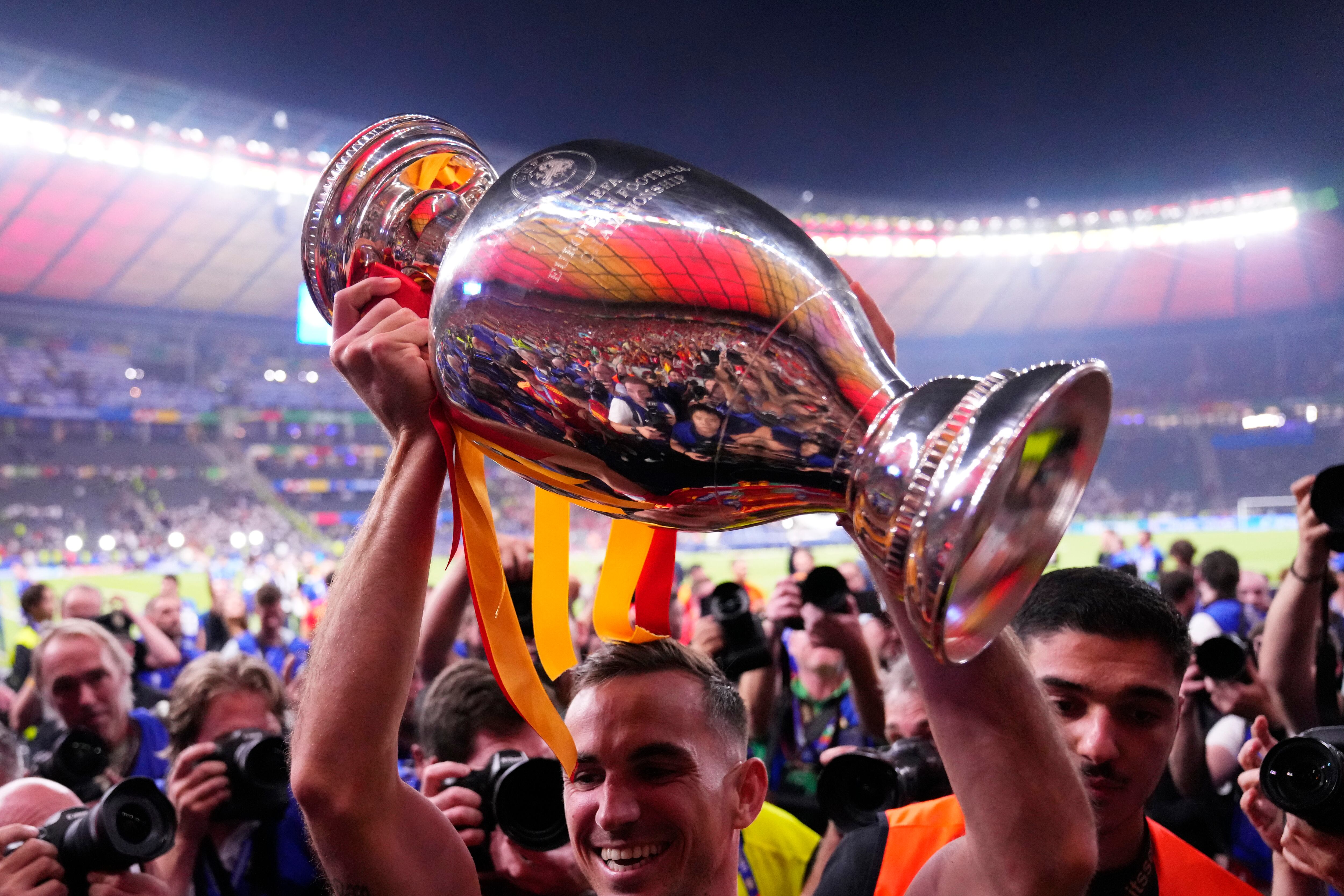 Spain's Dani Olmo holds up the trophy to the fans after winning the final match between Spain and England at the Euro 2024 soccer tournament in Berlin, Germany, Sunday, July 14, 2024. Spain won 2-1. (AP Photo/Manu Fernandez)