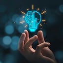 Mano sujetando el dibujo de la bombilla virtual con el cerebro en el fondo del bokeh para el concepto de idea de pensamiento creativo e inteligente