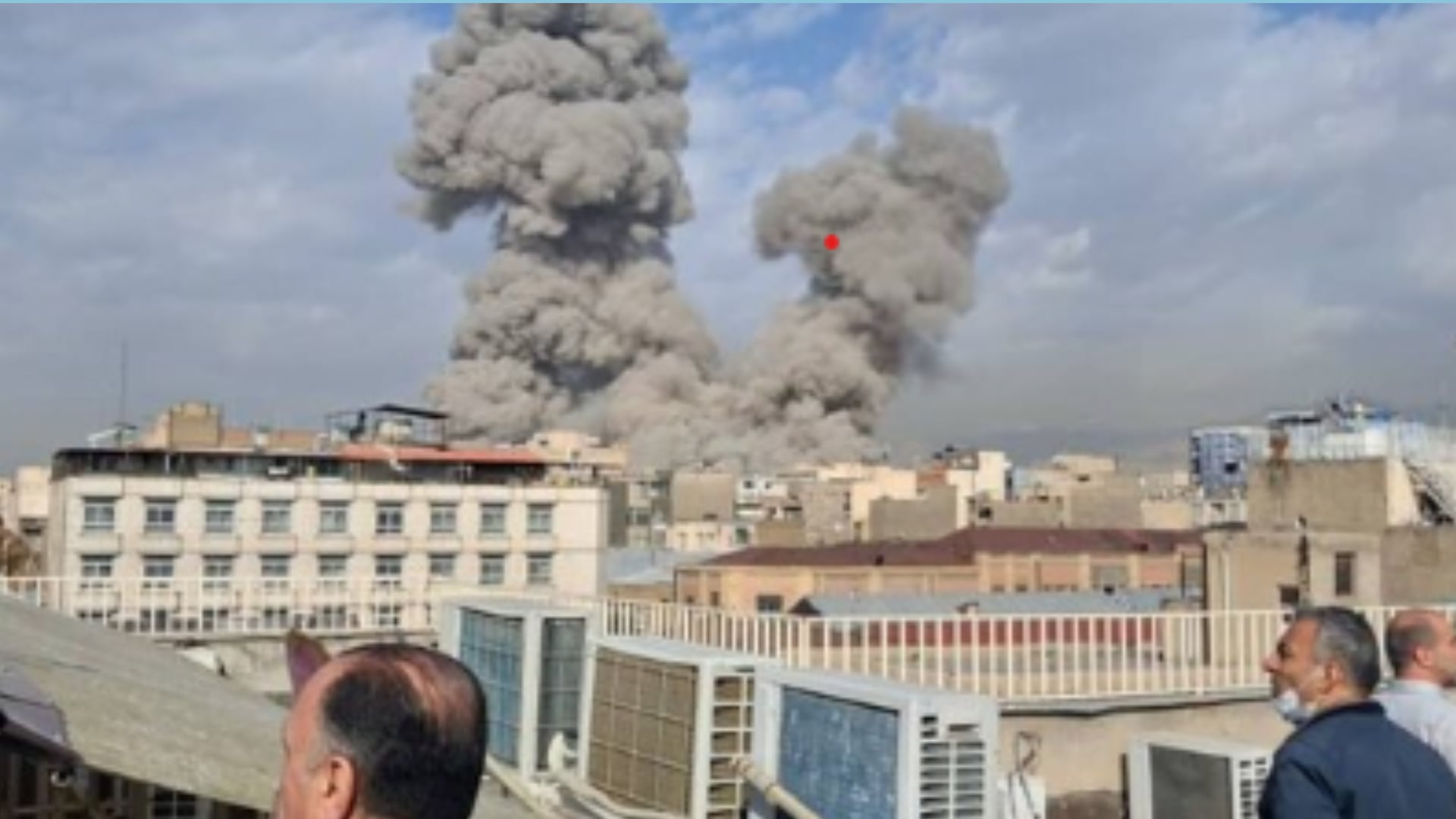 Columnas de humo se elevan tras el bombardeo registrado en la ciudad, mientras equipos de emergencia inspeccionan la zona afectada.