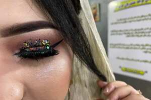 In this photograph taken on October 18, 2021, a customer shows her make-up done by a beautician at a beauty salon in Kabul. - It is one of the last places in Kabul where women can meet outside their households, a bubble of freedom and even frivolity away from the gaze of men. (Photo by Maryke Vermaak / AFP) / TO GO WITH Afghanistan-women-beauty,SCENE by Daphne Rousseau