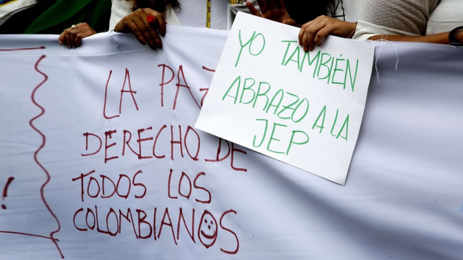 Participantes sostienen mensajes a favor de la Jurisdicción Especial de Paz (JEP) durante el acto simbólico