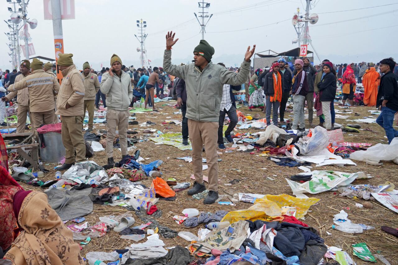 Un policía hace gestos en medio de pertenencias de devotos hindúes tras una estampida cuando los fieles corrieron para tomar un baño sagrado en el Sangam, la confluencia de los ríos Ganges, Yamuna y el mítico Saraswati, en la "Mauni Amavasya" o luna nueva, durante el festival de Maha Kumbh en Prayagraj, India, el miércoles 29 de enero de 2925. (AP Foto/Deepak Sharma)