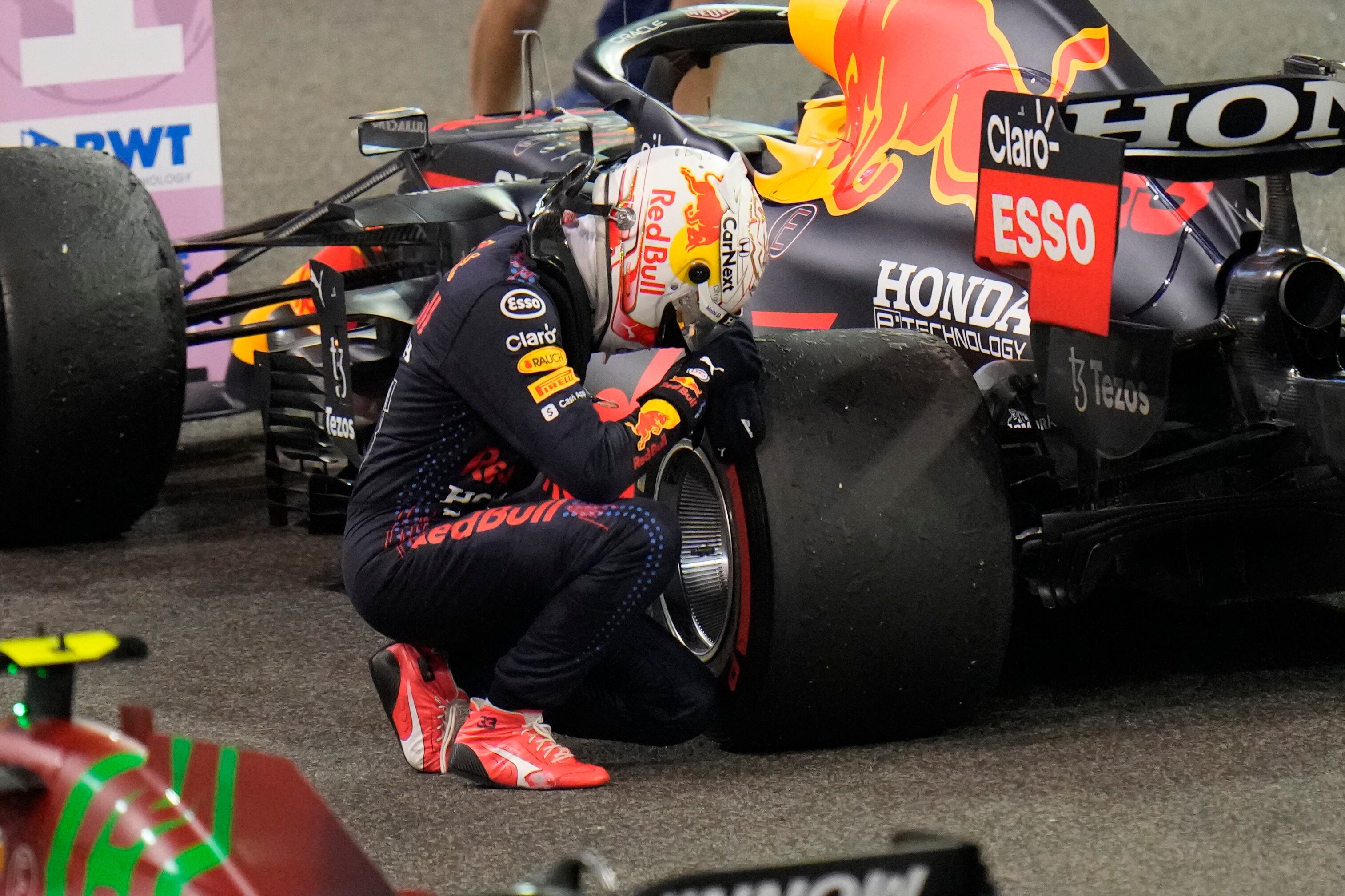 Red Bull driver Max Verstappen of the Netherlands kneels next to his car after he became the world champion after winning the Formula One Abu Dhabi Grand Prix in Abu Dhabi, United Arab Emirates, Sunday, Dec. 12, 2021. (AP Photo/Kamran Jebreili, Pool)