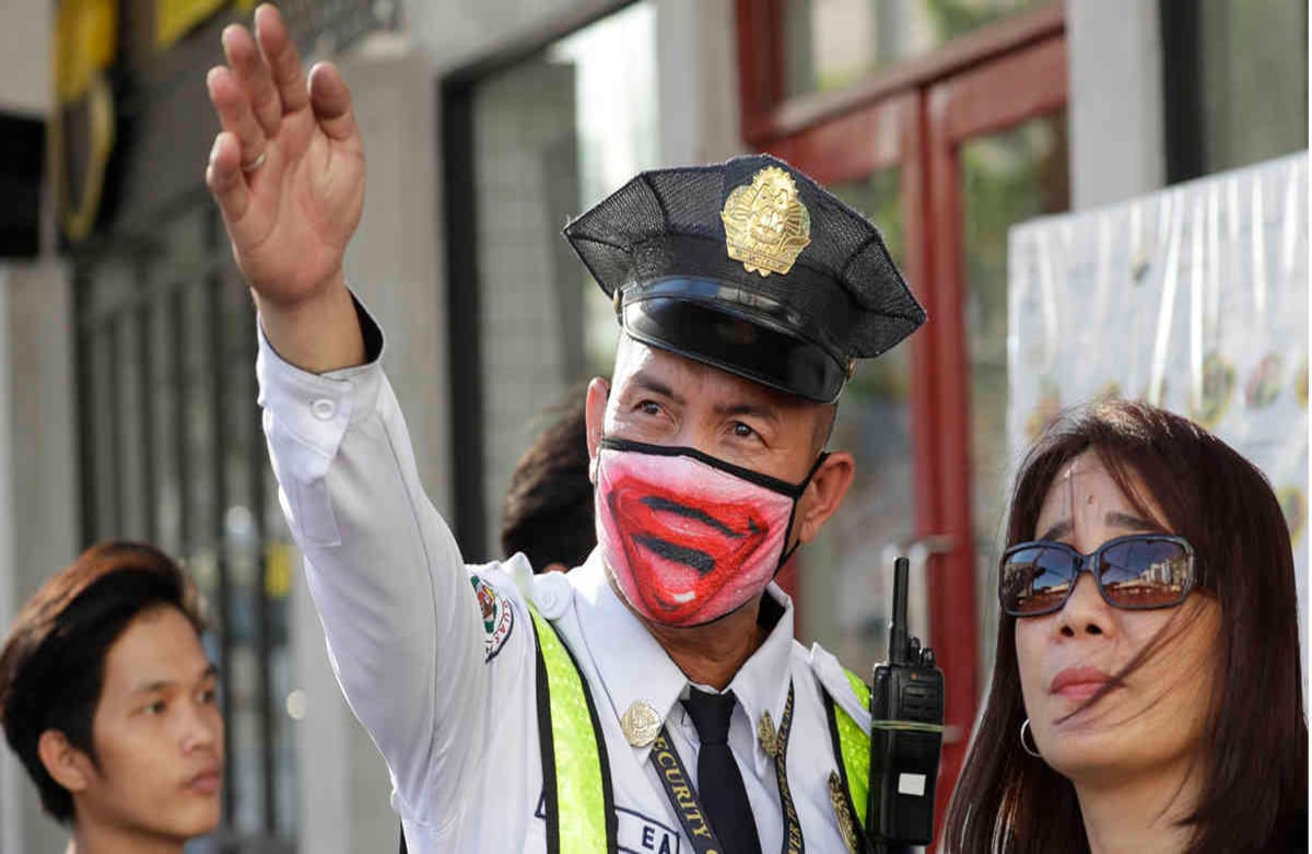 En Filipinas, muchas personas ajustaron sus planes de viaje antes de que el gobierno suspendiera los vuelos nacionales hacia y desde el área metropolitana de Manila. El presidente, Rodrigo Duterte, ordenó cuarentena en la capital para frenar el coronavirus. En la imagen, un guardia de seguridad orienta a una mujer, este viernes en la capital.  Foto: Aaron Favila/ AP 