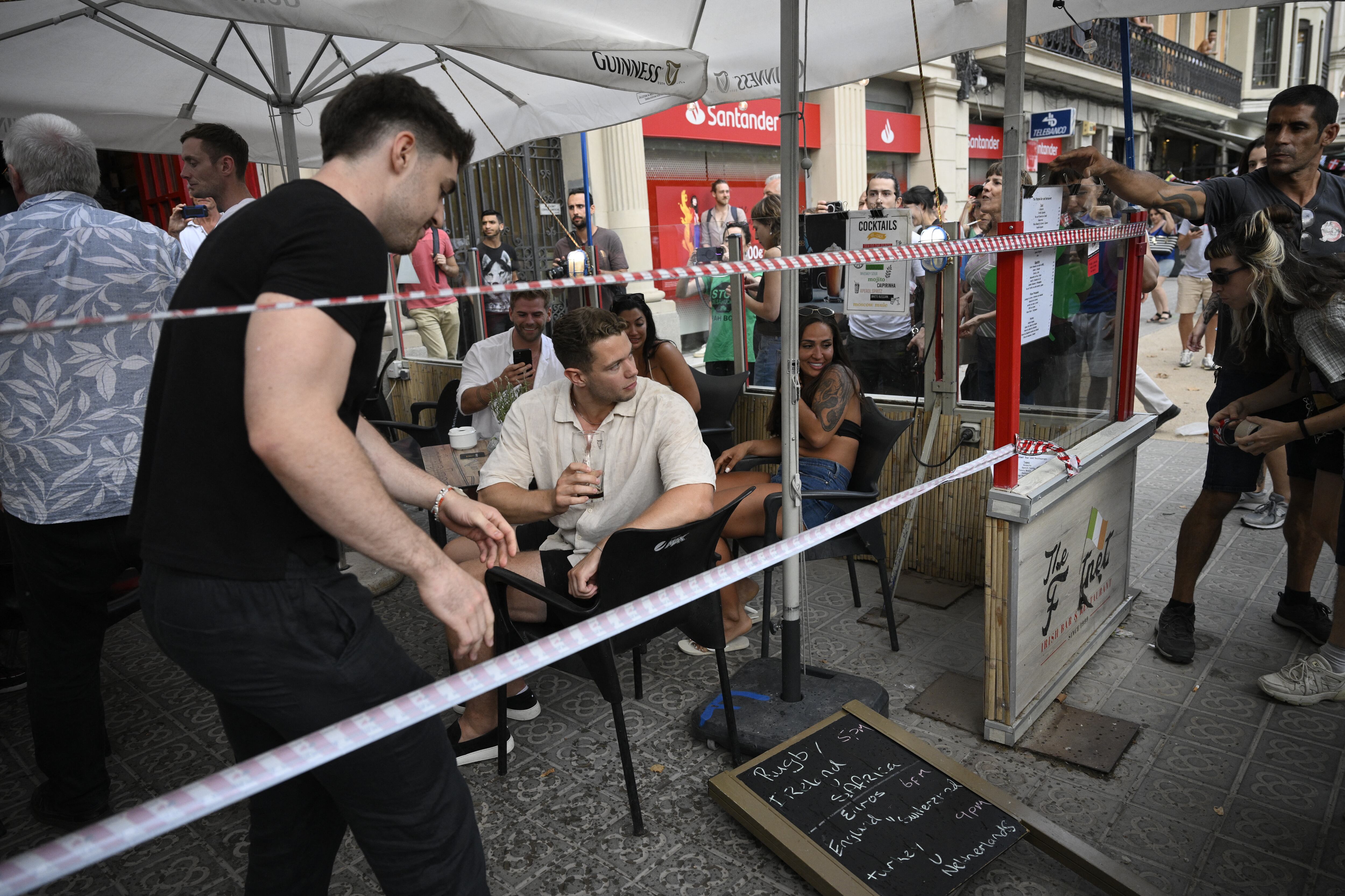 Los manifestantes colocaron un cordón simbólico en la ventana de un bar-restaurante durante una protesta contra el turismo de masas en el callejón de Las Ramblas de Barcelona, ​​el 6 de julio de 2024