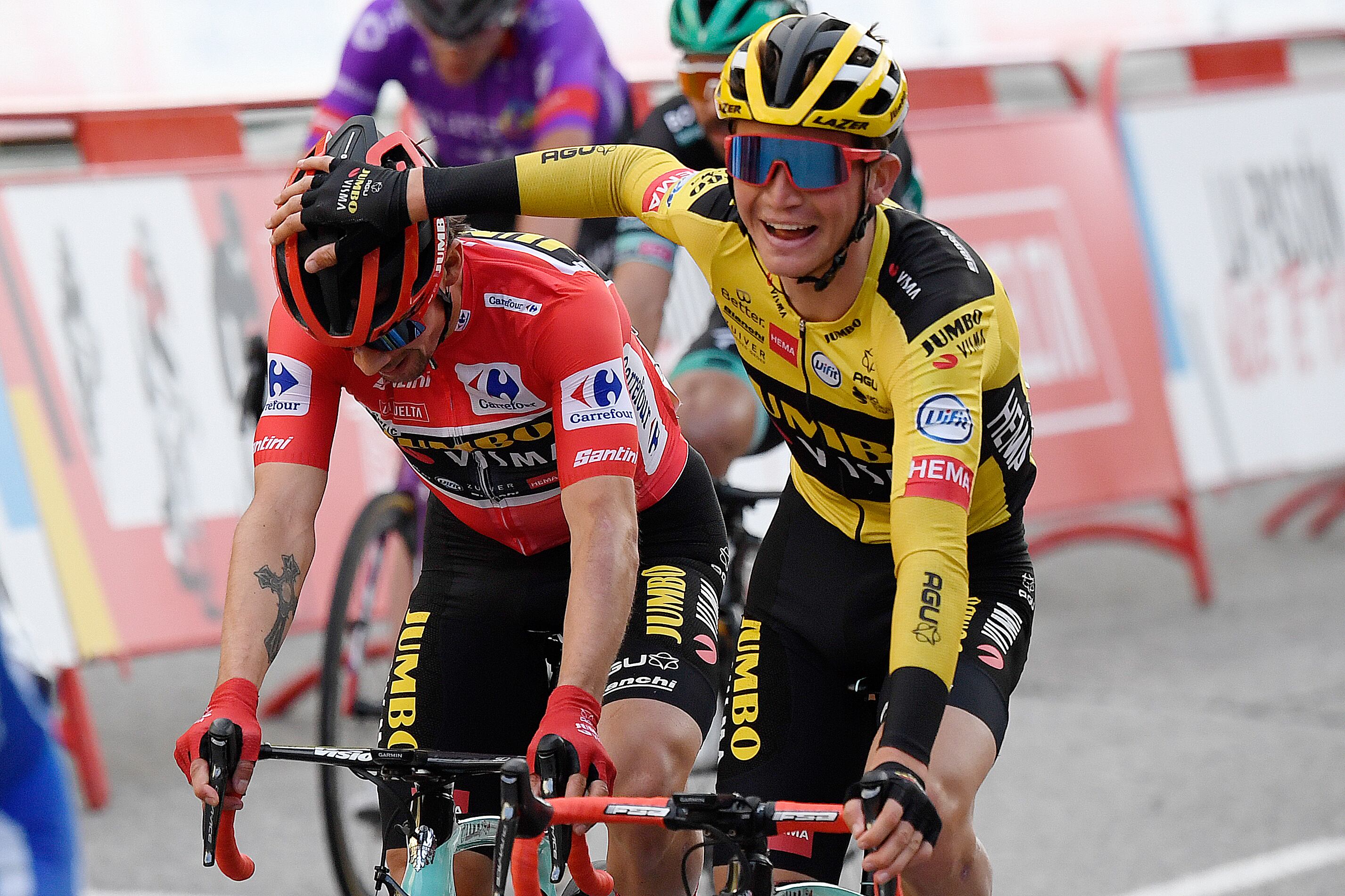 Team Jumbo's Slovenian rider Primoz Roglic (L) is congratluated for winning the 2020 La Vuelta at the end of the 18th and final stage of the 2020 La Vuelta cycling tour of Spain, a 124,2-km race from the Zarzuela racecourse to central Madrid, on November 8, 2020. (Photo by OSCAR DEL POZO / AFP)