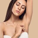 Depilación de axilas, depilación lacer. Mujer joven levantando los brazos y mostrando las axilas limpias, depilación piel suave y clara. Retrato de belleza