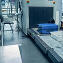 Imagen de referencia: oficial y perro de detección inspeccionando equipaje en el aeropuerto.