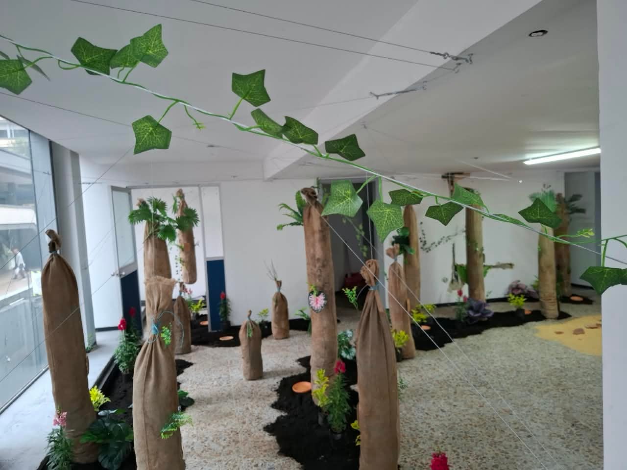 La instalación artística utiliza elementos naturales y tierra para representar la relación con el territorio y las raíces.
