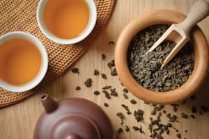Tea leaves spilling out from wooden bowl, near the Freshly brewed tea