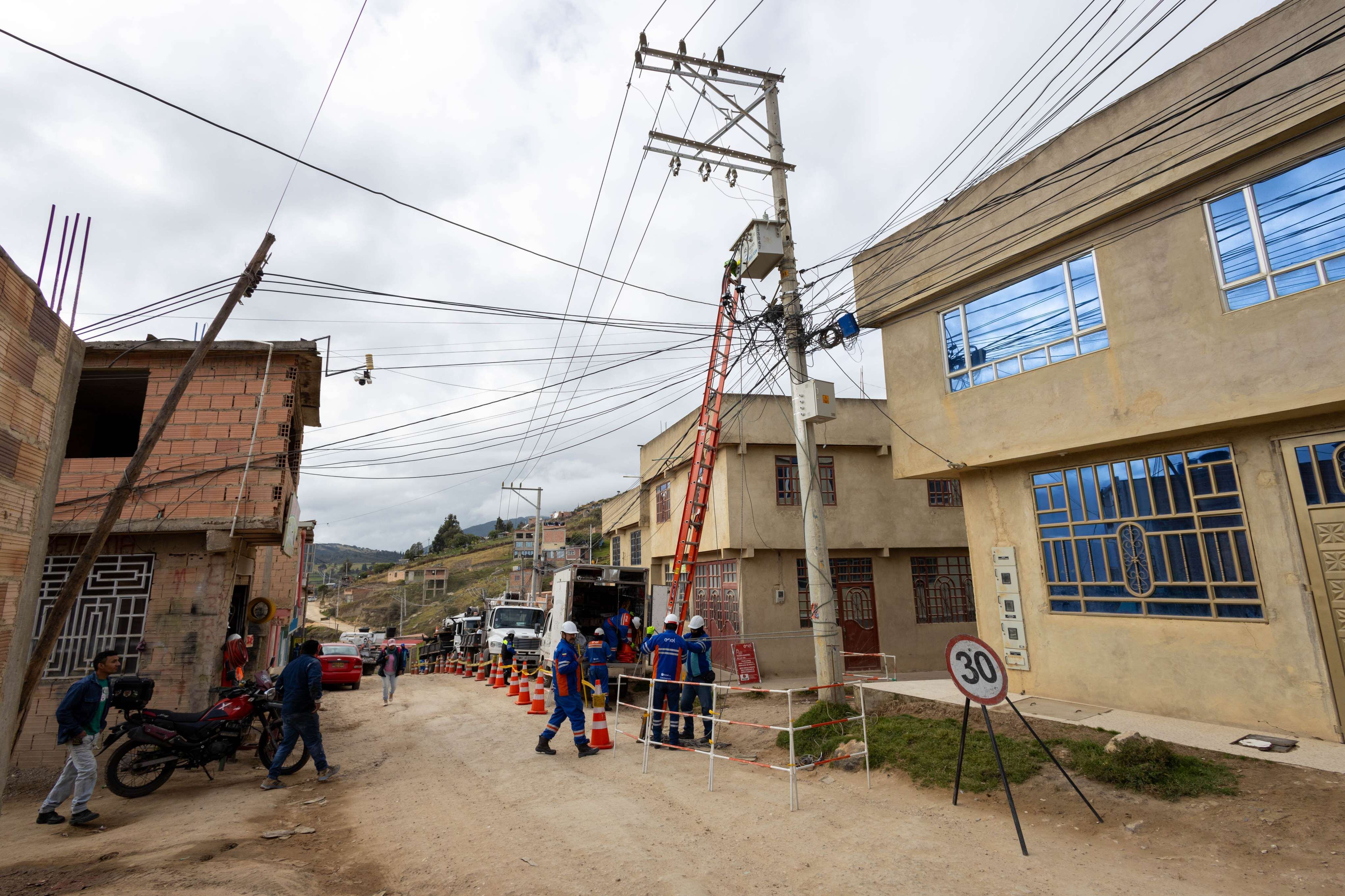 Trabajadores durante las labores de conexión eléctrica en el barrio El Triunfo, Ciudad Bolívar.