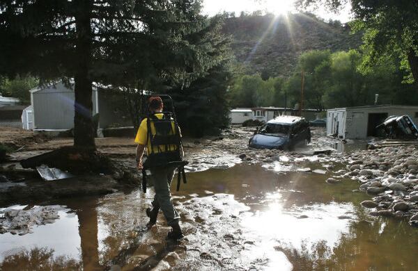 Un residente en Colorado, Estados Unidos, ayuda a un amigo a recuperar lo que dejó las inundaciones de viviendas e infraestructura del pueblo de Lyons. (AP)