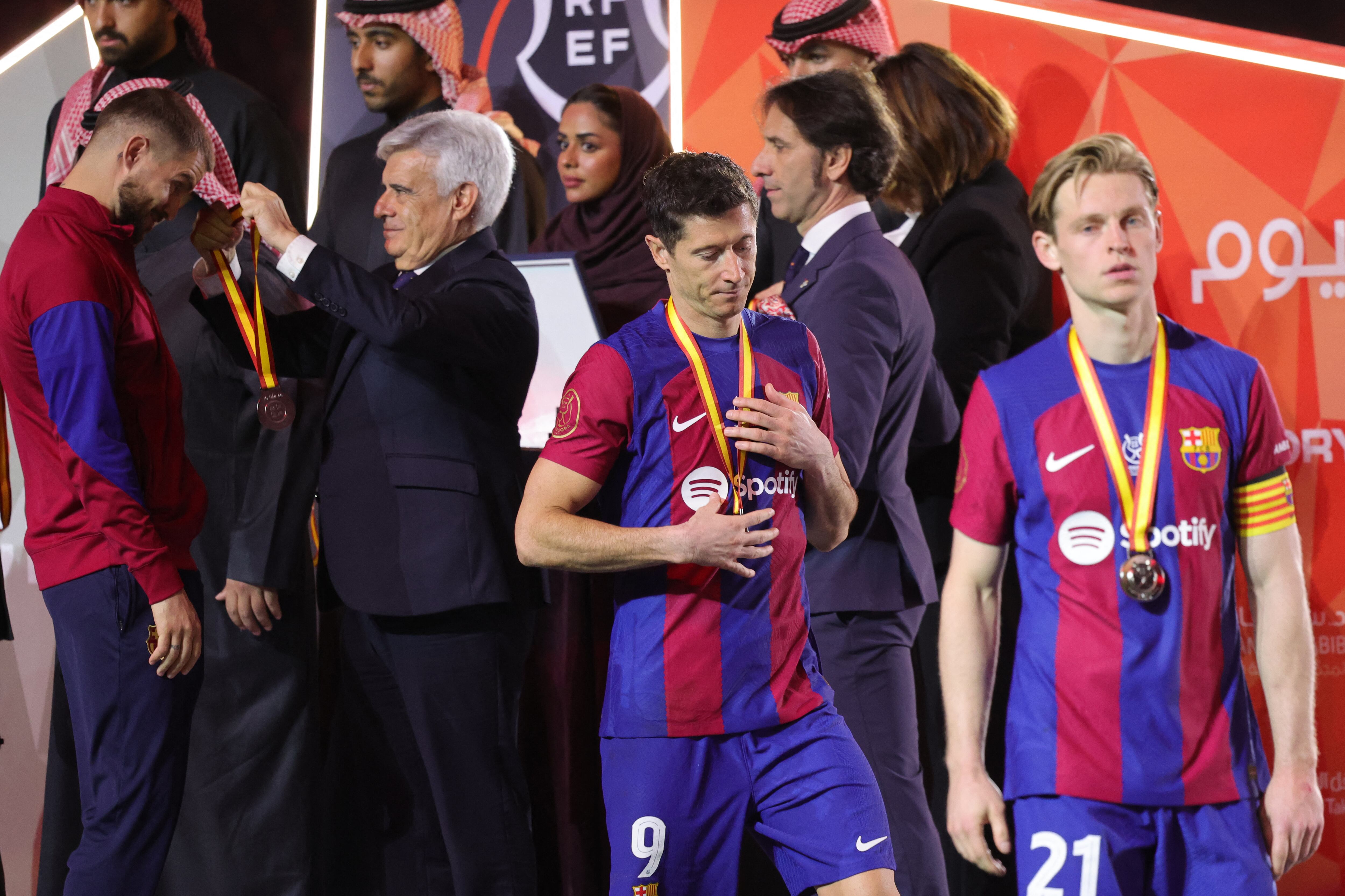 Barcelona's Dutch midfielder #21 Frenkie de Jong and Barcelona's Polish forward #09 Robert Lewandowski walk during the medal ceremony after the Spanish Super Cup final football match between Real Madrid and Barcelona at the Al-Awwal Park Stadium in Riyadh, on January 14, 2024. (Photo by Giuseppe CACACE / AFP)