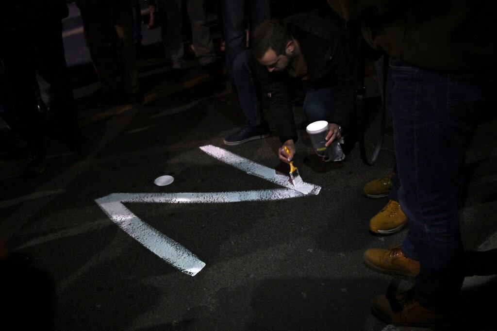 Un manifestante pinta el cartel "Z" en una calle, en referencia a los tanques rusos marcados con la letra, durante una manifestación organizada por organizaciones serbias de derecha en apoyo de la invasión rusa en Ucrania, en Belgrado el 4 de marzo de 2022 (Foto de Andrej ISAKOVIC / AFP)