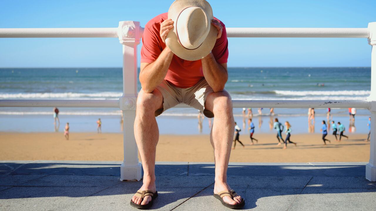 Un hombre preocupado. Al fondo, una playa