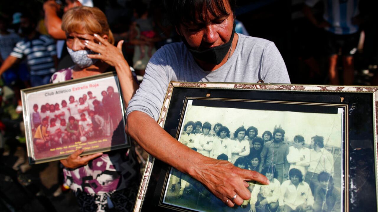 Un vecino señala a un joven Diego Maradona en una foto en la que hace fila con un equipo de fútbol local, frente a la casa donde nació en el barrio de Villa Fiorito en Buenos Aires.