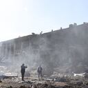 Los espectadores toman fotografías frente al centro comercial y de entretenimiento en la ciudad ucraniana de Odessa, en el Mar Negro, el 10 de mayo de 2022, destruido después del ataque de misiles rusos el 9 de mayo de 2022. (Foto de Oleksandr GIMANOV / AFP)