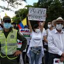 Una mujer sostiene un cartel que dice en español "No más bloqueos" durante una marcha silenciosa para apoyar el desbloqueo de las principales vías de entrada y salida de la ciudad que han sido bloqueadas por protestas antigubernamentales en Cali, Colombia, el martes 25 de mayo de 2021. Los colombianos han salido a las calles durante semanas en todo el país luego de que el gobierno propusiera aumentos de impuestos a los servicios públicos, combustible, salarios y pensiones. (Foto AP / Andrés González)
