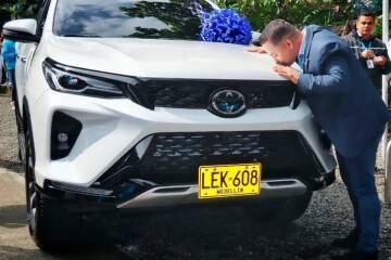 Personero de Medellín dándole un beso a una camioneta de la entidad.